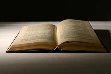 Old book on table on black background