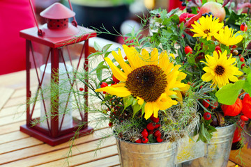 Blumen und Laterne auf Gartentisch