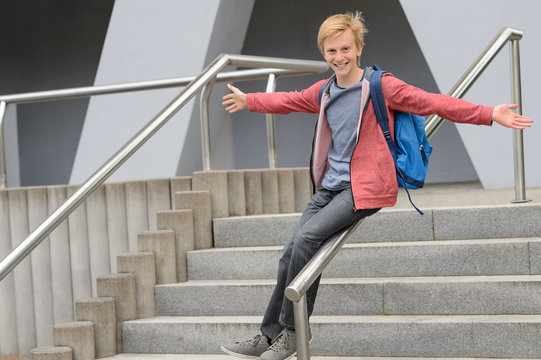 Playful Student Sliding Down Handrail On Stairway