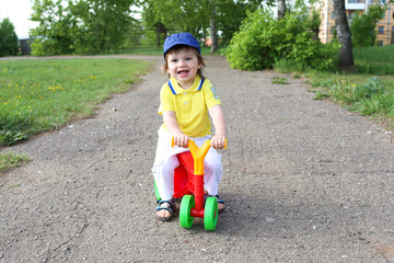 baby on plastic run bike outdoors