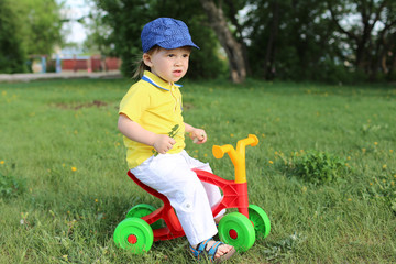baby boy on plastic run bike outdoors