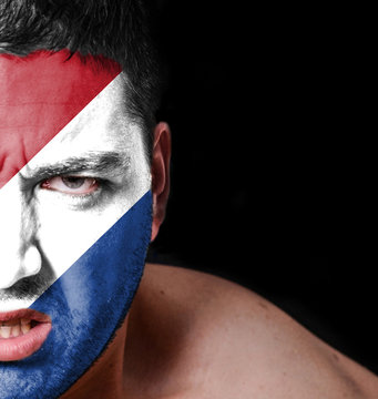 Portrait of angry man with painted flag of Netherlands