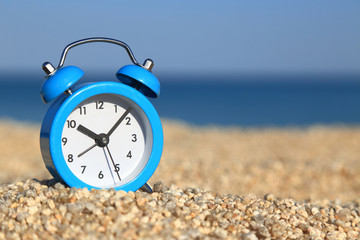 Vacation time. Alarm clock on the beach