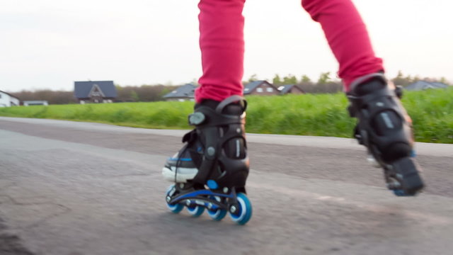 Happy young girl riding on roller blades