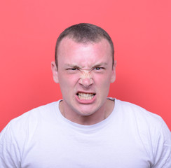 Portrait of angry man screaming and pulling hair against red bac
