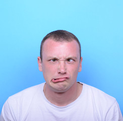 Fototapeta premium Portrait of girl with funny face against blue background