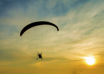 Silhouette paramotor in sunset.