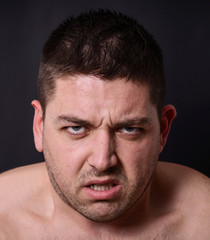 Obraz premium Portrait of angry man against dark background