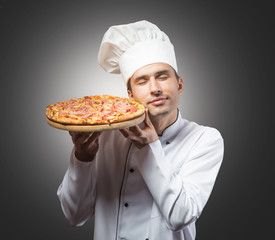 Portrait of a chef with closed eyes smelling pizza