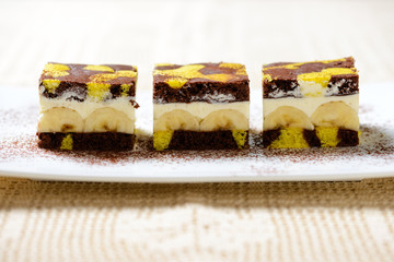 Zweifarbiger Kuchen gefüllt mit Bananen und Sojaschlagcreme