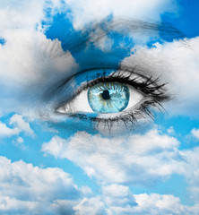 Beautiful blue eye against blue clouds - Spiritual concept