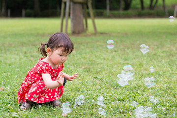 シャボン玉で遊ぶ少女
