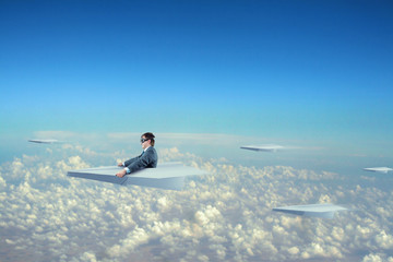 Businessman flying on paper plane