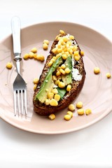 rye sandwich with corn, avocado and cheese