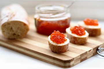 Red caviar in spoon on a baguette