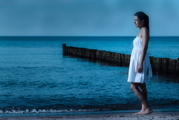 Schöne Frau am Strand im Mondschein