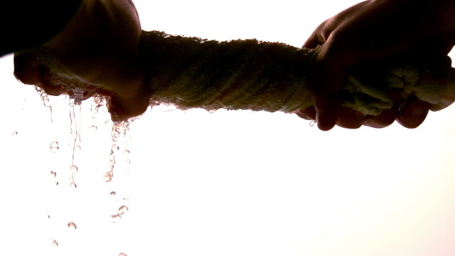 Hands wringing out washrag on white background