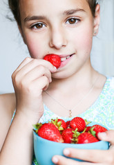 child eating a strawberry