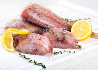 Sea bass with lemon on wooden board