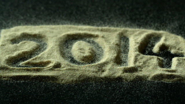 2014 spelled out in sand blowing away