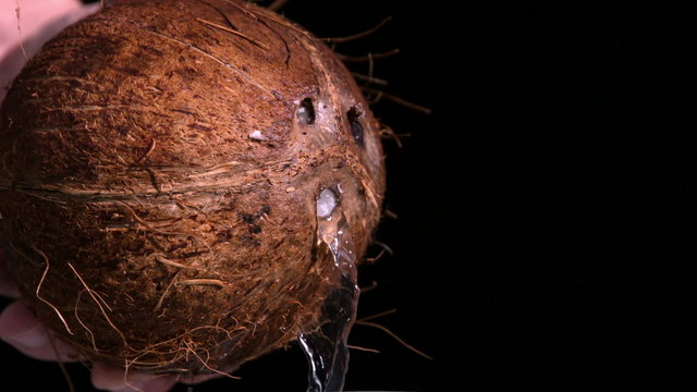 Water Leaking Out Of Coconut On Black Background