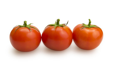 Three tomatoes in a row on white background