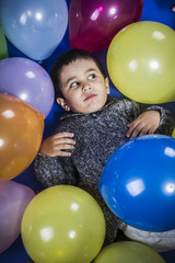 Funny boy playing with balloons of many colors