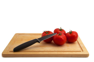 Tomaten mit Messer auf Holzbrett