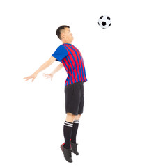 Fototapeta na wymiar Young soccer player jumping to stop ball by chest