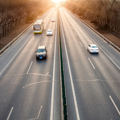 Cars in motion blur on street during sunset