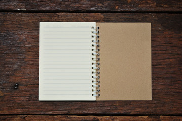 Brown notebook on a wood background