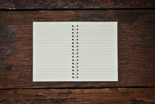 Brown notebook on a wood background