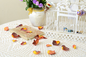 The book on a table with rose petals