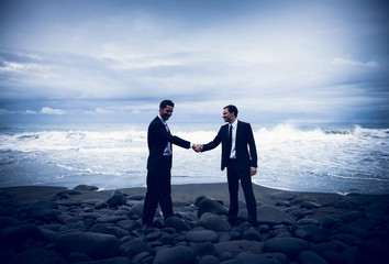Fototapeta premium Businessmen Shaking Hands With Stormy Ocean Background