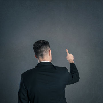 Young Businessman Back View With Pointing Finger And Copy Space