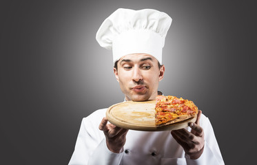 Humorous portrait of a man in chef's hat looking at pizza