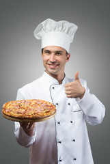 Smiling chef with fresh pizza showing thumbs up