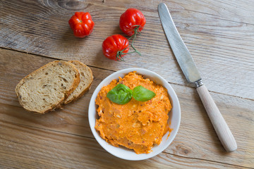 Kräuterbutter Tomate in einer Schale auf Holz