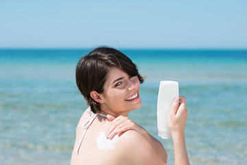 frau am strand benutzt sonnencreme