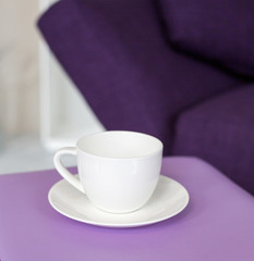 cup and purple couch