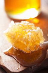 honeycomb and honey in jar on wooden background
