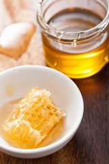 honeycomb and honey jar on wooden background