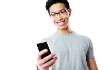 Fototapeta premium Smiling asian man using smartphone on gray background