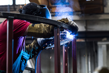 welder with protective mask welding metal and sparks