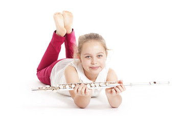 young  girl holding flute lying on the floor © ahavelaar