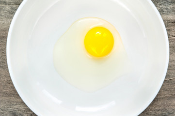 Quail eggs yellow yolk in white porcelain bowl. Closeup.
