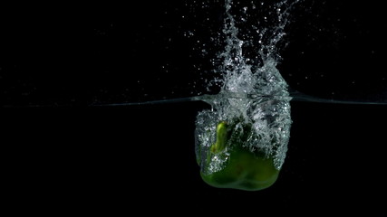 Green pepper falling in water on black background - Powered by Adobe