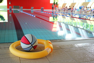 Ball und Schwimmnudel am Rand eines Sportbeckens