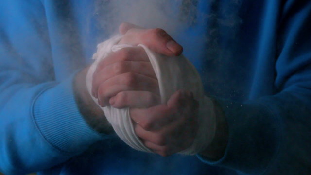 Young boxer clapping his wrapped hands together