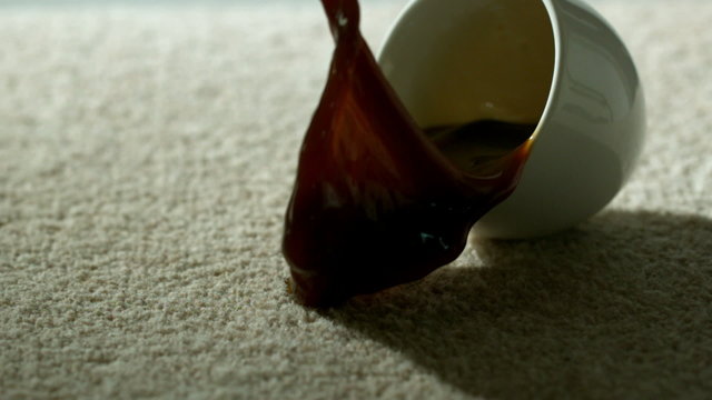Cup of coffee falling and spilling over carpet